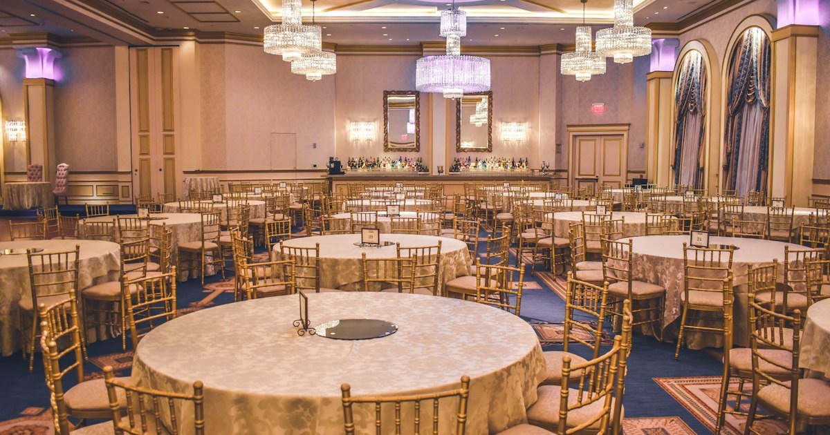 Mesa de banquete de boda elegantemente decorada con flores, velas y copas de cristal