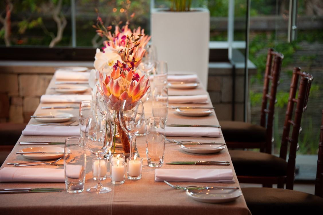 Centro de mesa con arreglo floral y copas de cristal en un evento elegante
